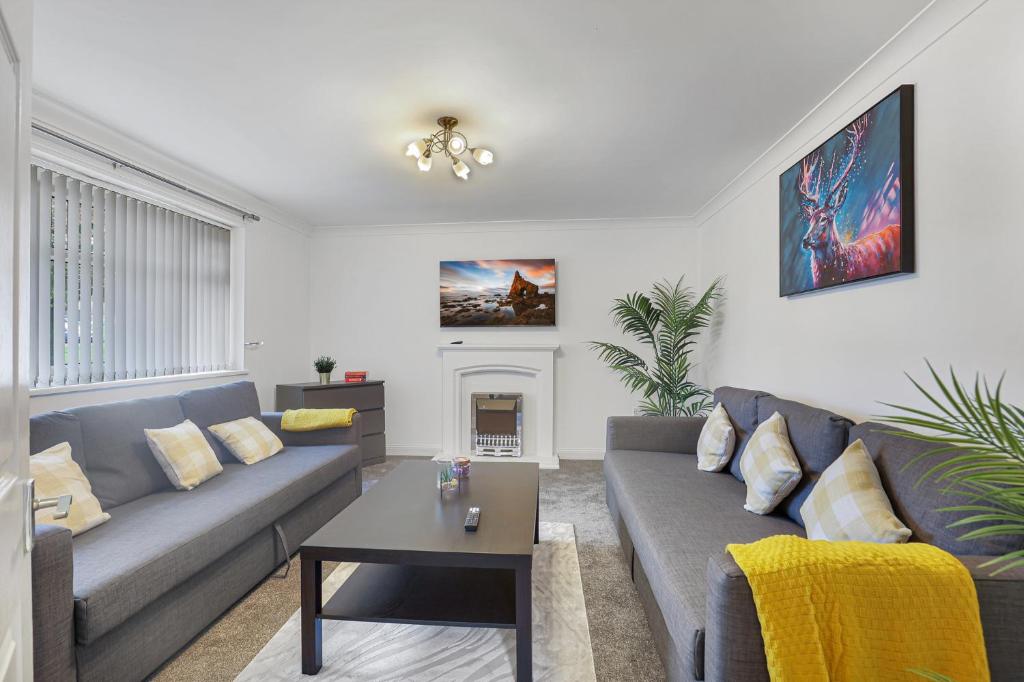 un salon avec un canapé et une cheminée dans l'établissement Spacious 4 Bedroom House with Parking, à Lamesley