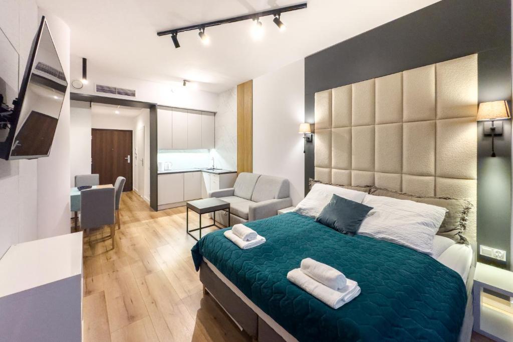 a bedroom with a large bed and a living room at ANS Hanza Tower Apartment no 410 - Swimming pool and saunas not opened from 12-28 November in Szczecin