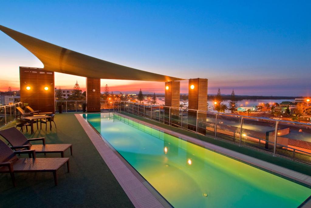 uma piscina no telhado de um edifício à noite em Mantra Quayside Port Macquarie em Port Macquarie