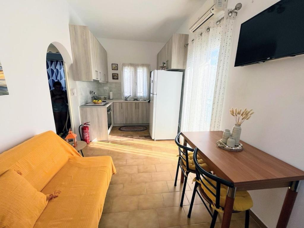 a living room with a couch and a table and a refrigerator at Cozy Corner Marmara Paros in Dhragoulás