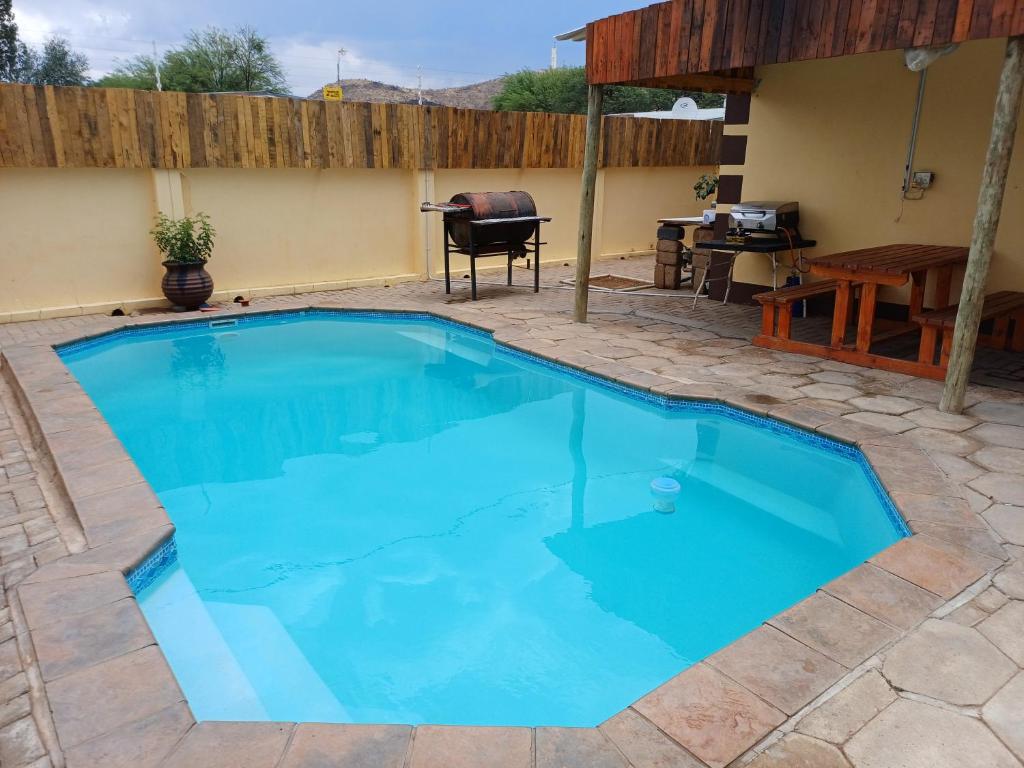 a large blue swimming pool in a patio with a table at Watergat guest house in Rehoboth