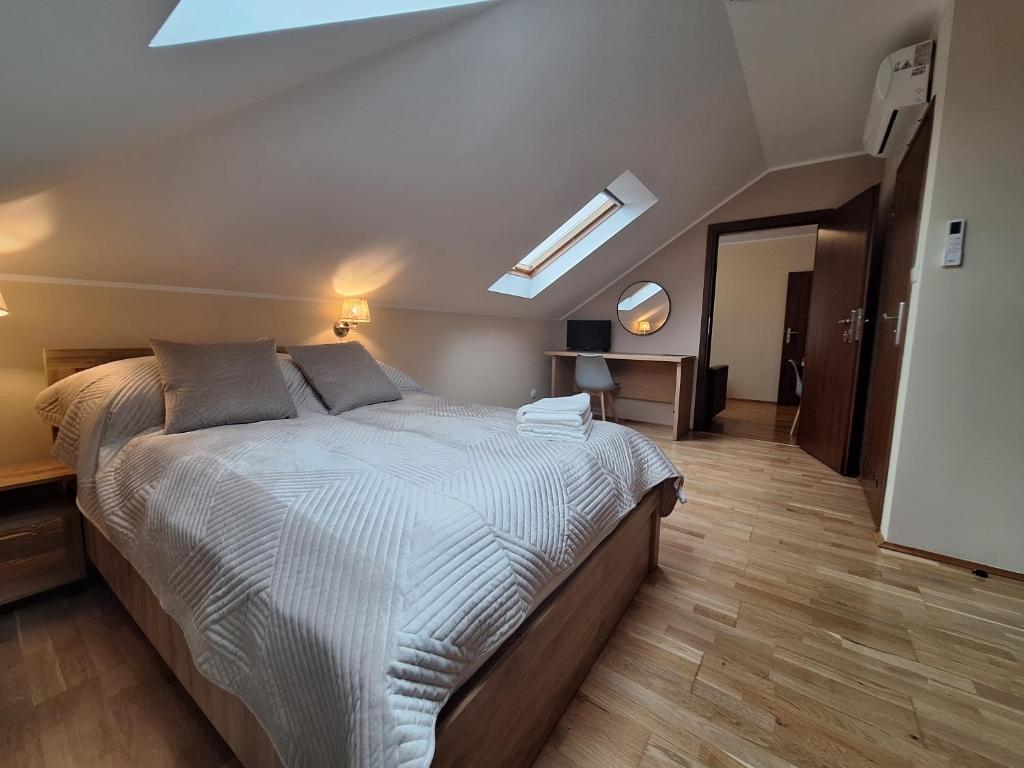 a bedroom with a large bed and a skylight at Aparthotel Xavito in Sanok