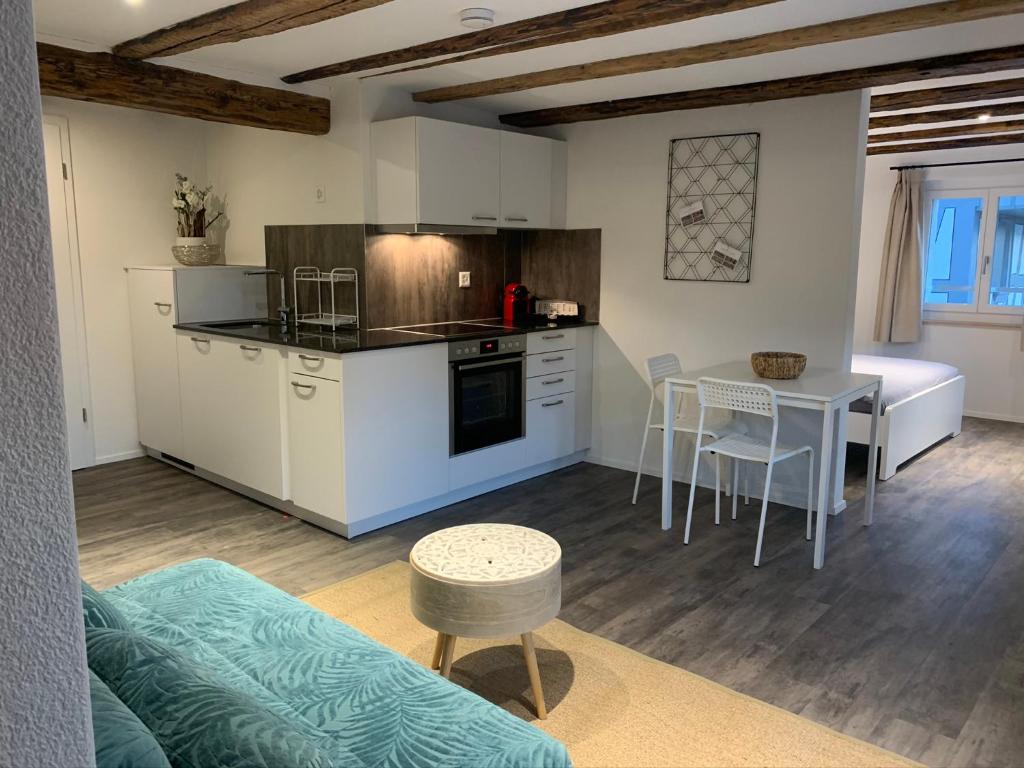 a kitchen with white cabinets and a table and a tableablish at smartroom Apartment in Wettingen in Wettingen