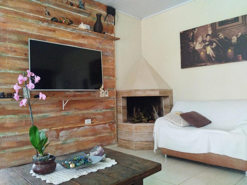 a living room with a wooden wall with a flat screen tv at summer house 2026 in Tramandaí