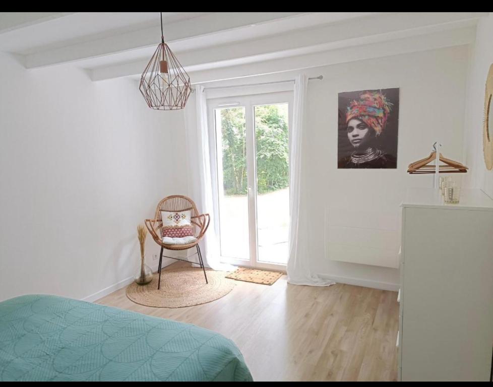 Cette chambre blanche dispose d'une chaise et d'une fenêtre. dans l'établissement Lamaisondubois31, à Pibrac