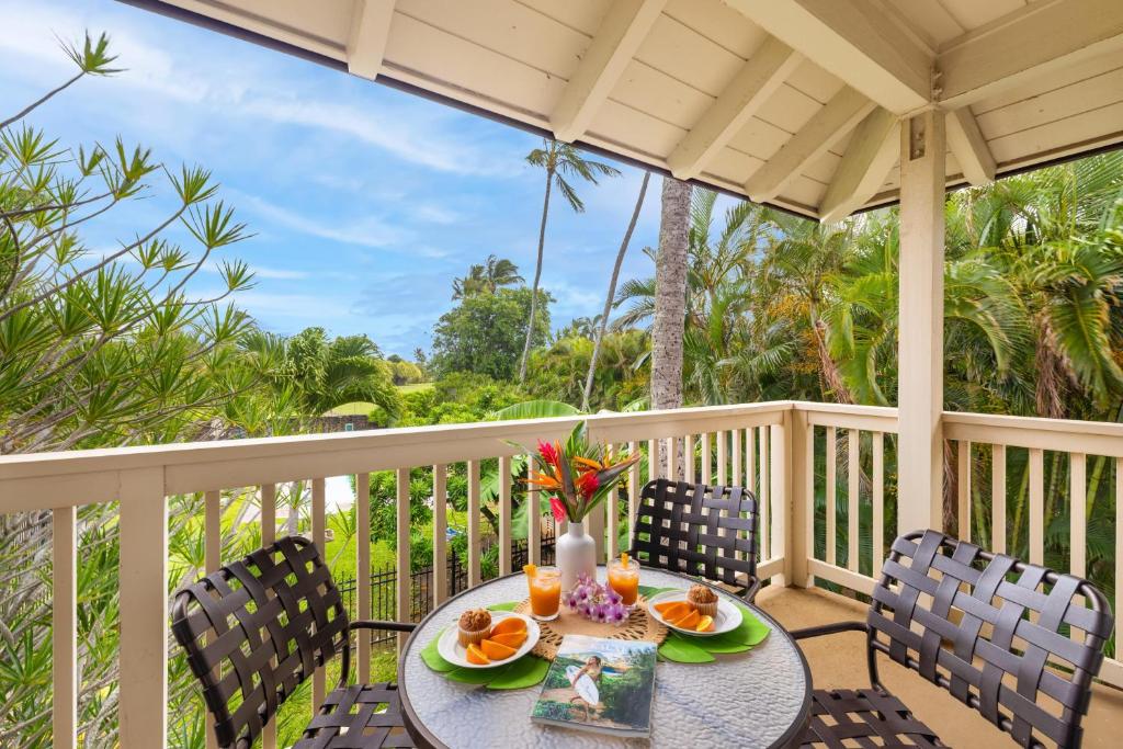 a table and chairs on a porch with a view of the ocean at Regency 620 in Koloa