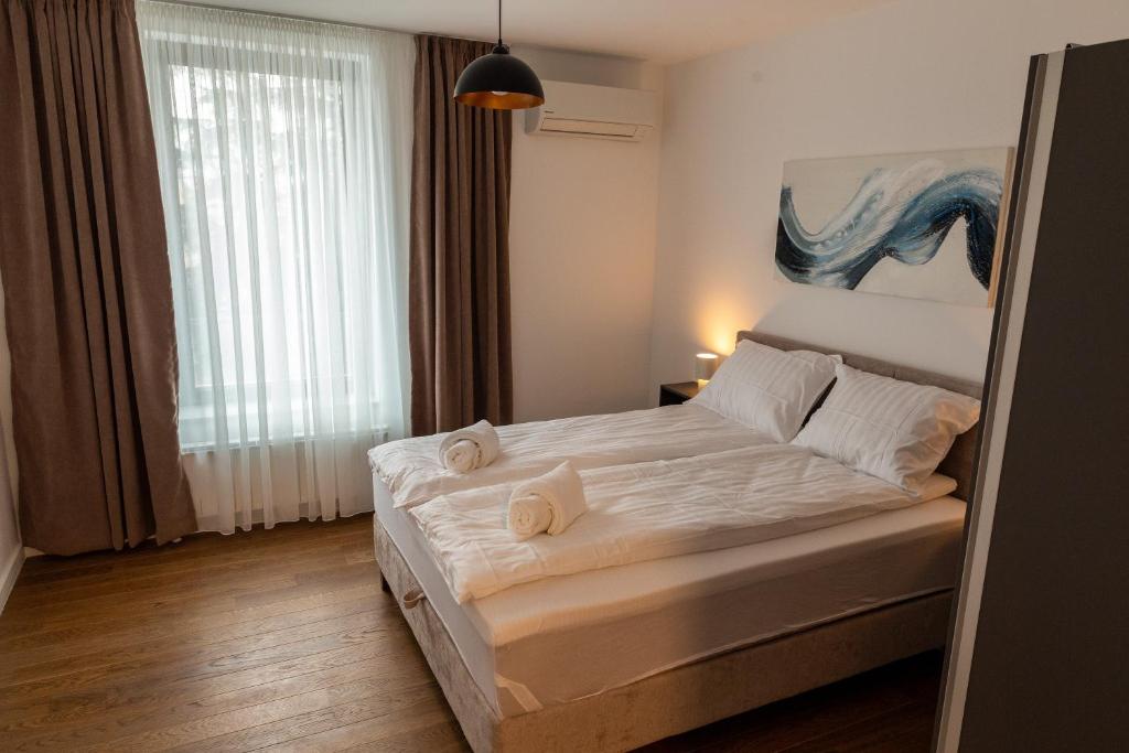 ein Schlafzimmer mit einem Bett mit zwei Handtüchern darauf in der Unterkunft Planet Gemini Residence in Niš