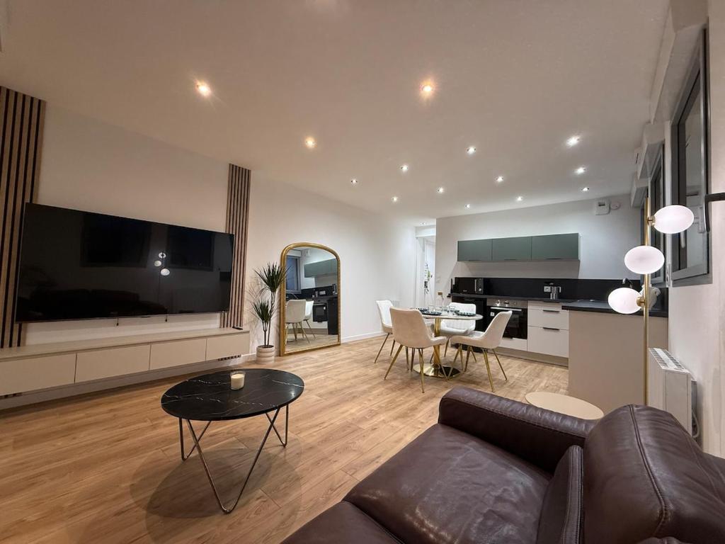 ein Wohnzimmer mit Sofa und Tisch in der Unterkunft T2 neuf marbre et or - écran géant - Netflix in LʼHermitage