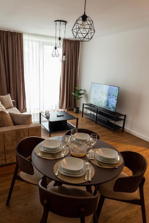 a living room with a table with plates on it at Planet Gemini Residence & SPA in Niš