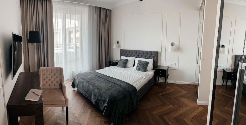 a bedroom with a bed and a table and a chair at Lumina OVO in Wrocław