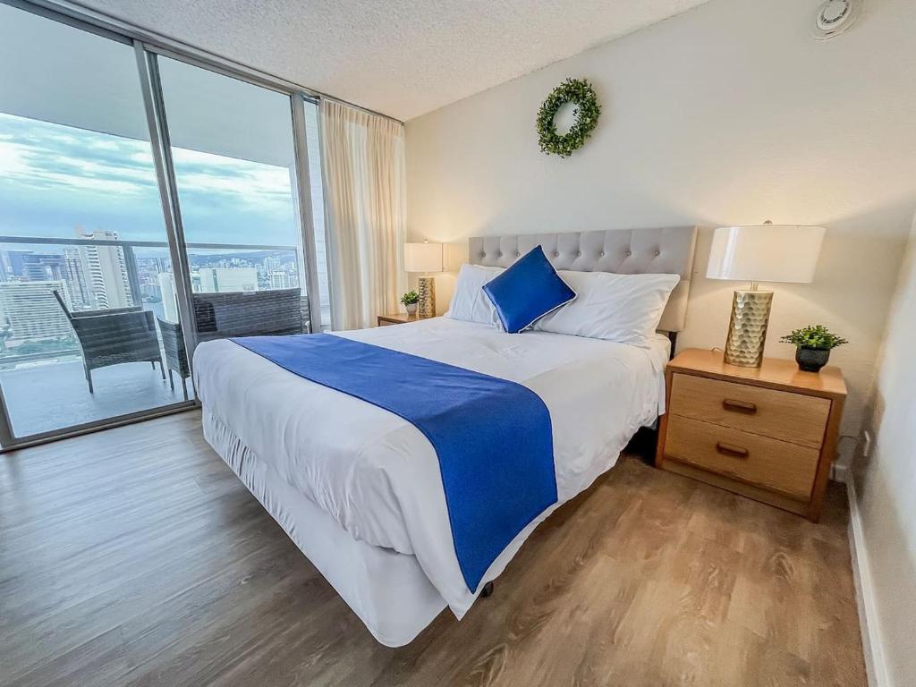 a bedroom with a large bed and a large window at Two Amazing Views in One Spacious Condo Getaway in Honolulu