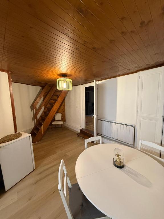 een eetkamer met een witte tafel en stoelen bij Face au chateau in Vizille