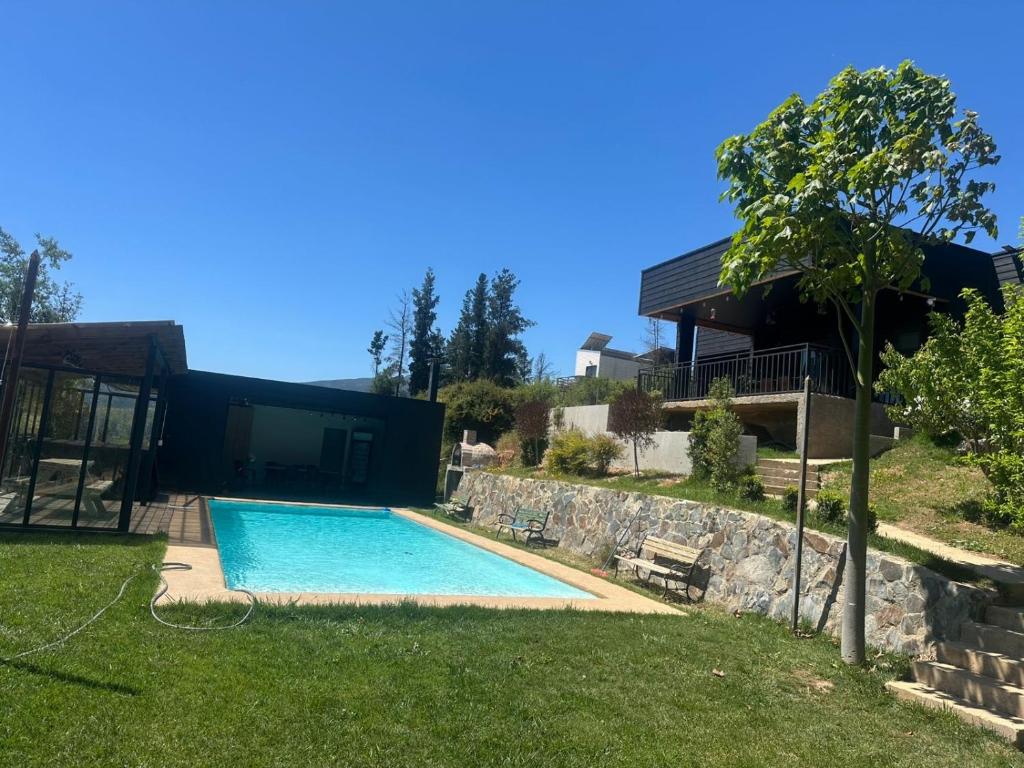 a swimming pool in a yard next to a house at Casa El Quillay in Los Quillayes