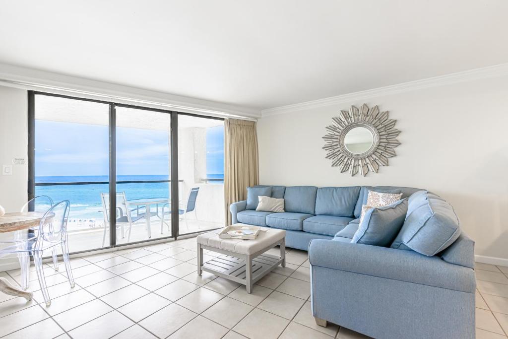 Una sala de estar con un sofá azul y una mesa. en Beachside Two 4287, en Destin