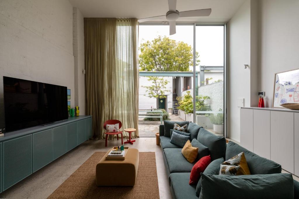 a living room with a blue couch and a tv at Chic Seddon Retreat Near the CBD in Seddon