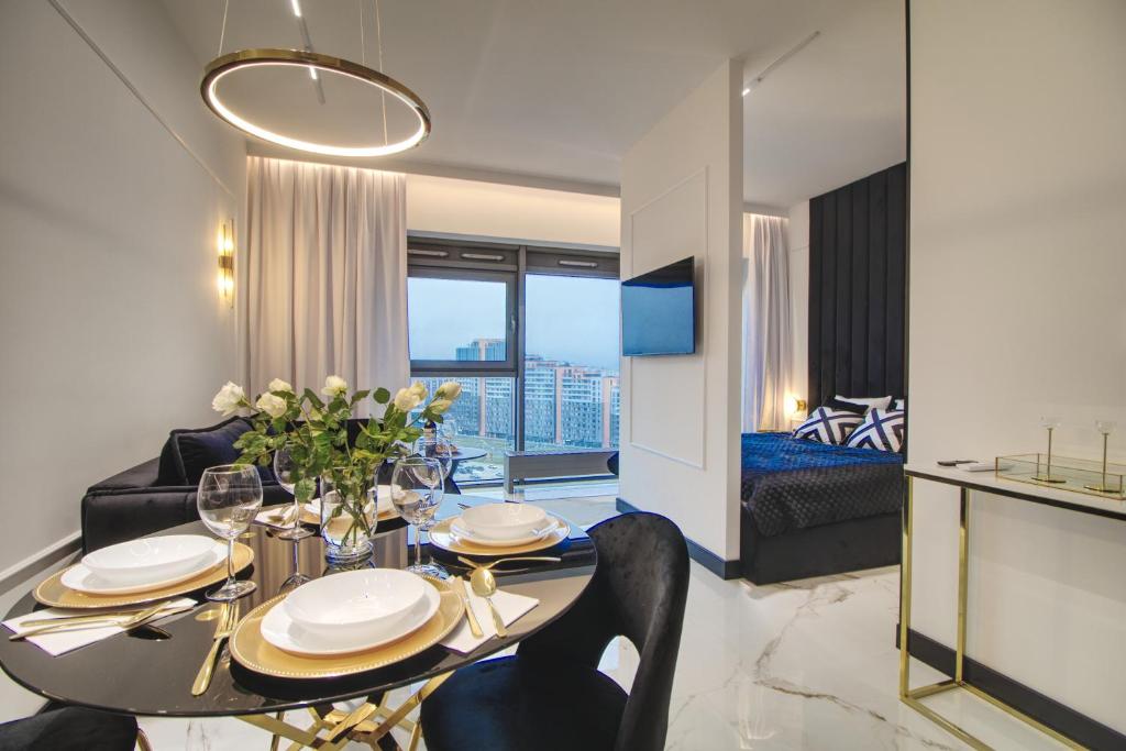 uma sala de jantar e sala de estar com mesa e cadeiras em Apartament Glamour Olszynki Park em Rzeszów