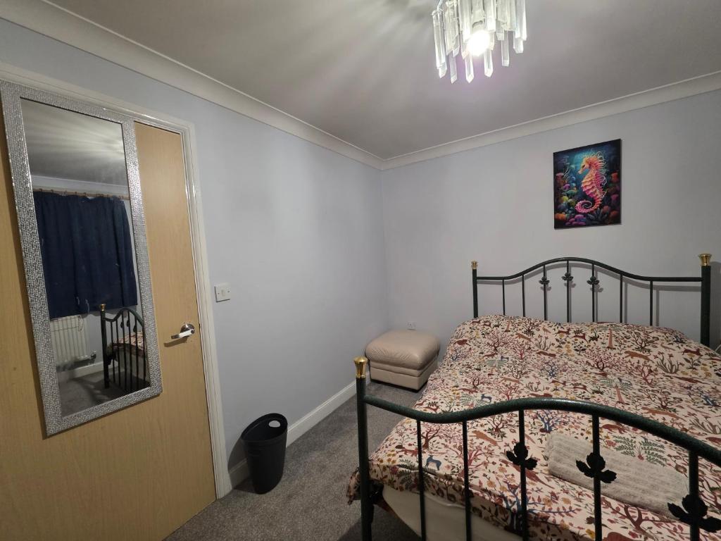 a bedroom with a bed and a mirror and a door at Home away from city noise Be in Hythe