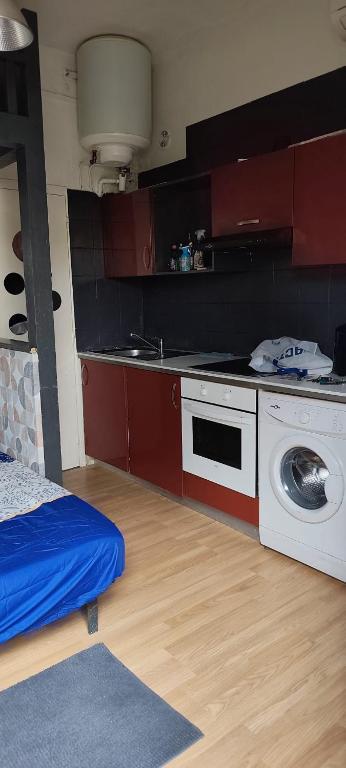 a kitchen with a stove and a washing machine at Studio propre disponible in Vigneux-sur-Seine
