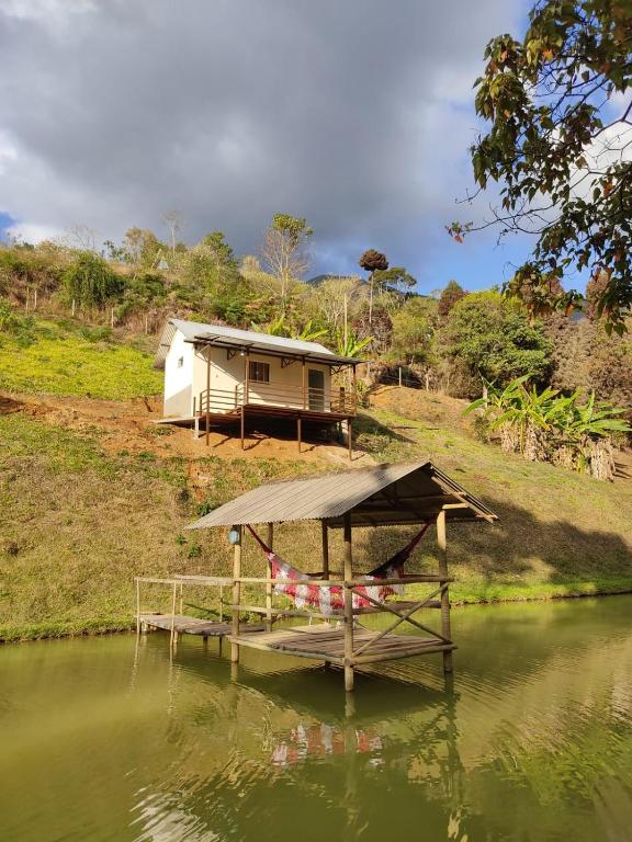 una casa con muelle y un barco en el agua en Chalé Roda Dágua C, en Caparaó Velho