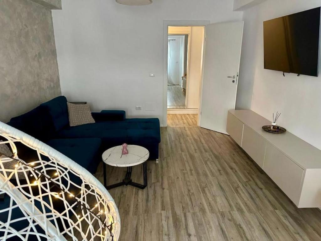 ein Wohnzimmer mit einem blauen Sofa und einem Tisch in der Unterkunft Apartament silver in Craiova