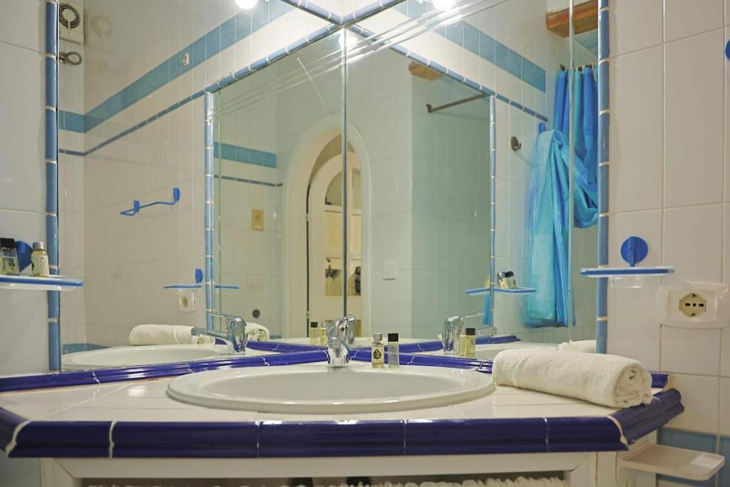 Un baño con lavabo y un espejo grande. en Casa Claudia - Positano Center 5 minutes to beach, en Positano