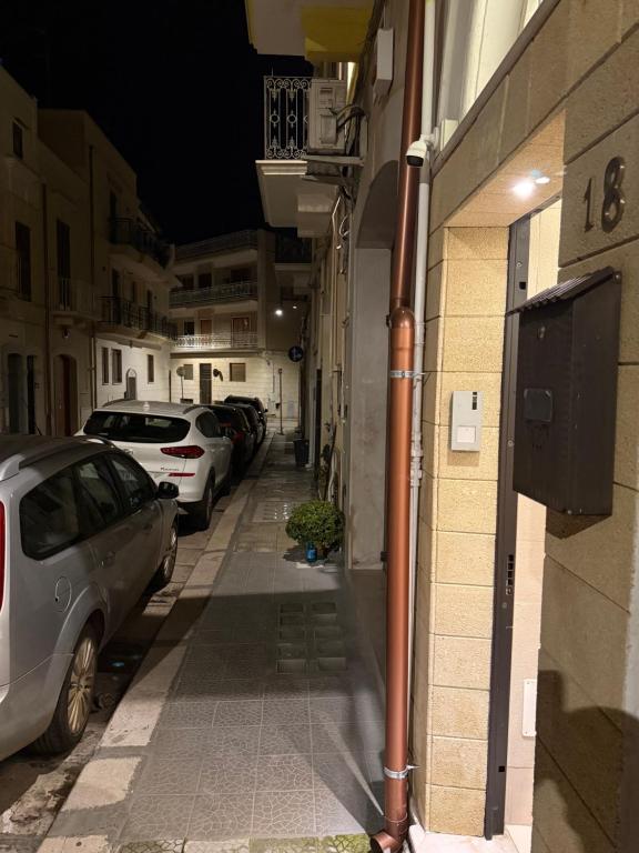 モーラ・ディ・バーリにあるLa Casa del Caribeの建物の脇に車が駐車されている路地