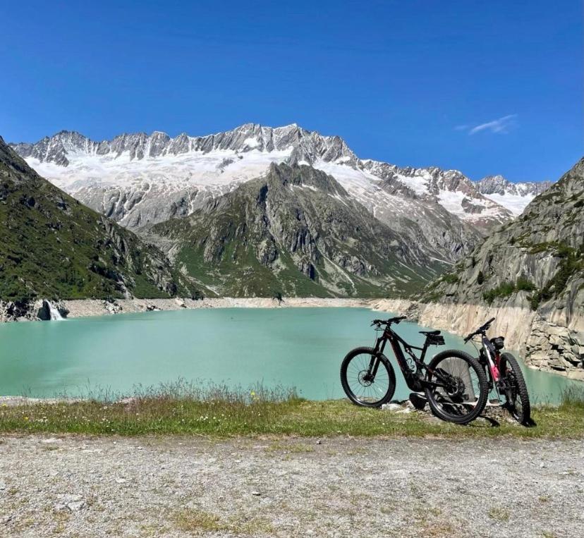 a motorcycle parked in front of a mountain lake at Dammablick Göschenen in Göschenen
