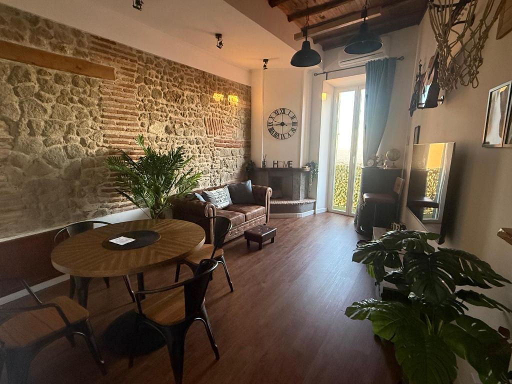 a living room with a table and a brick wall at Apartment La vista in Genzano di Roma