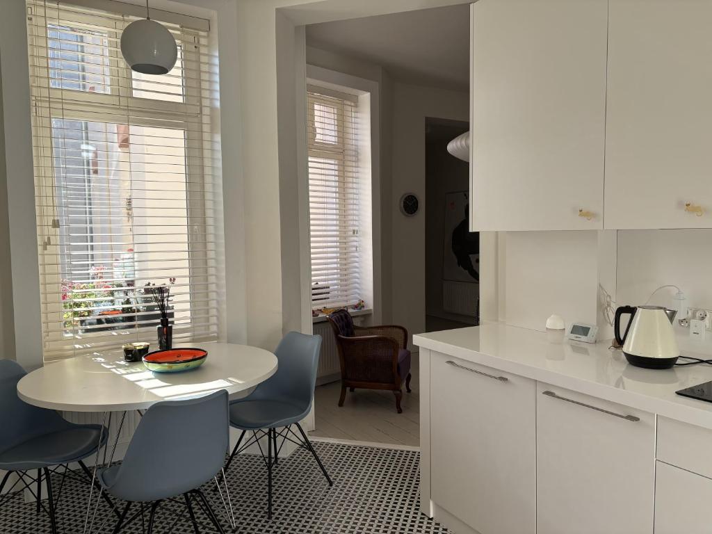 a kitchen with a white table and chairs and a table at Apartament Dominic in Sopot