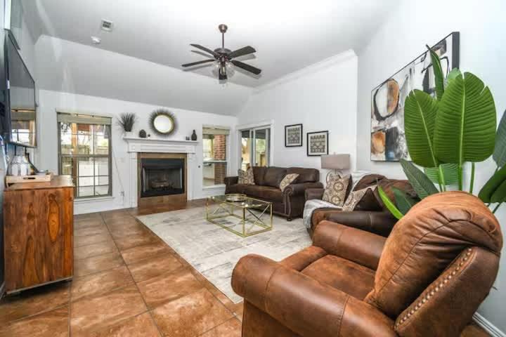 Una sala de estar con muebles de cuero y chimenea. en Cypress Ct Estate, en Siloam Springs