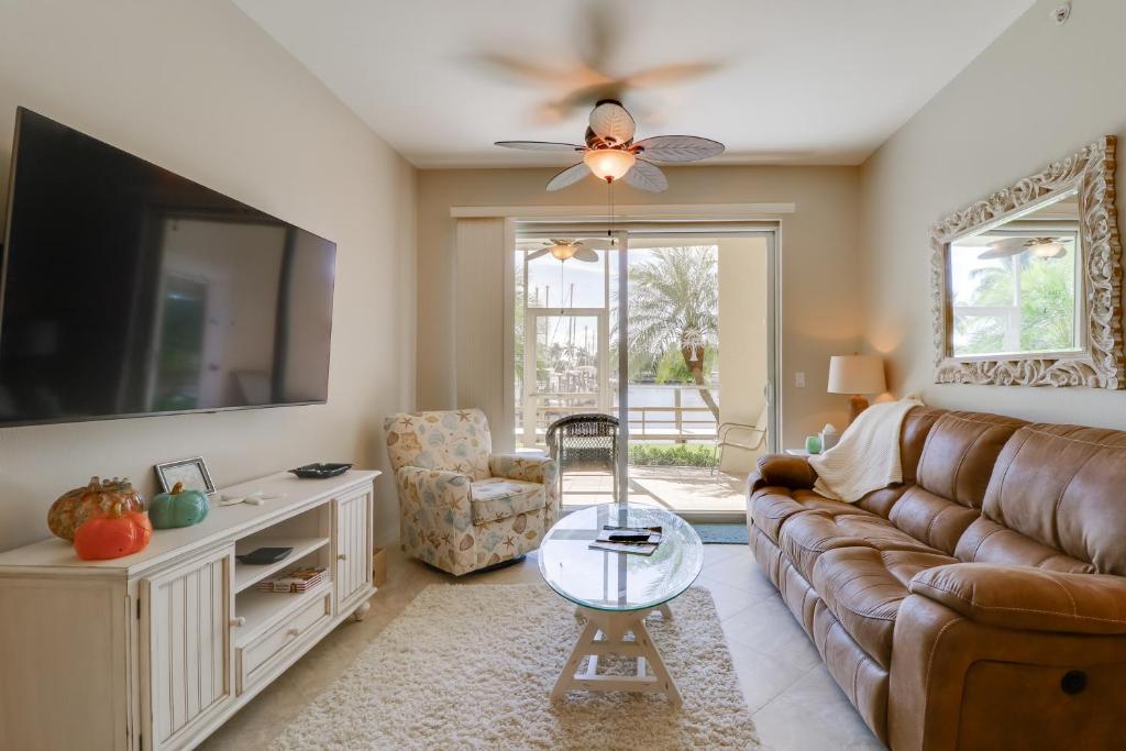a living room with a couch and a tv at Waterfront Punta Gorda Condo with Pool Access! in Burnt Store Marina
