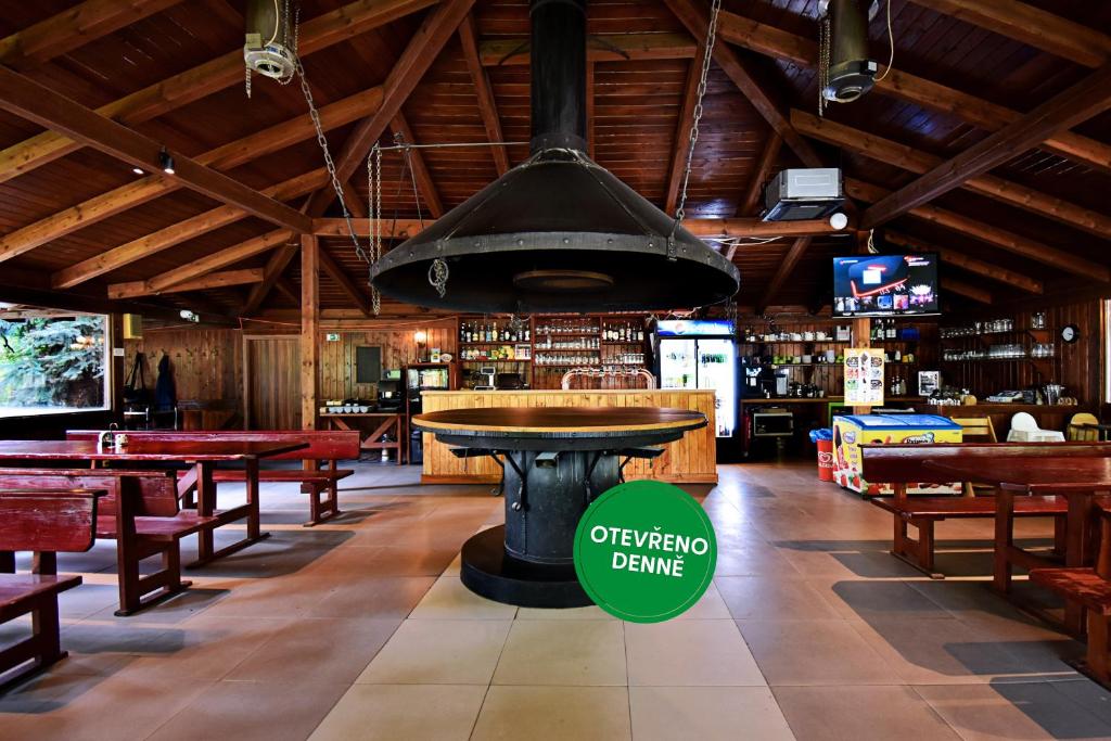 an empty restaurant with a large black pot hanging from the ceiling at Apartmány & Kemp Sázavský ostrov in Sázava