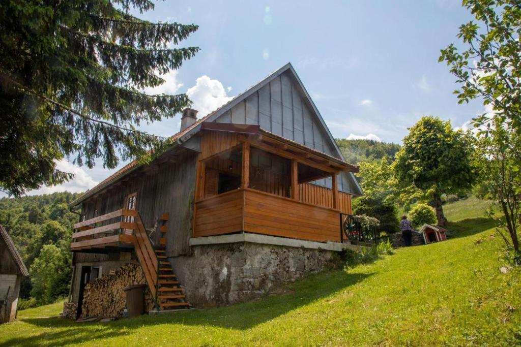 a large wooden house on a grassy hill at House Zeleni brig in Mrkopalj