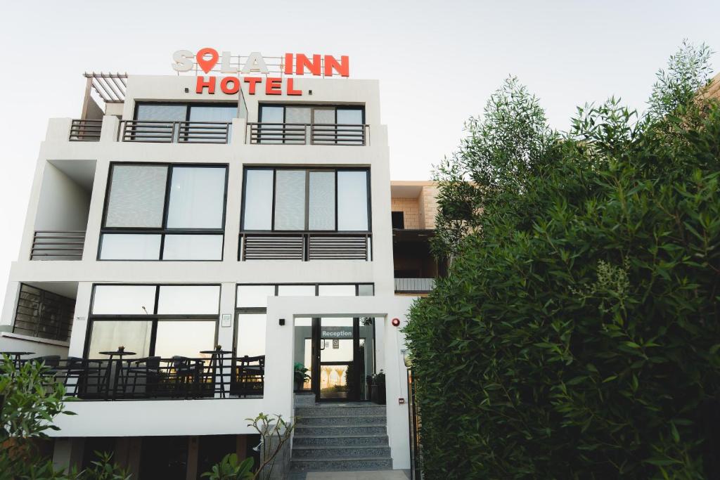ein weißes Gebäude mit einem Hotelschild darauf in der Unterkunft SOLA INN Hotel Airport in Hurghada
