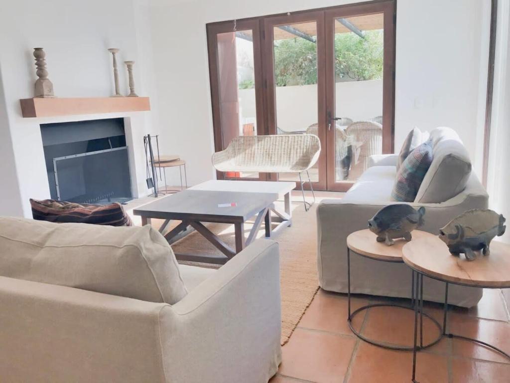 a living room with white furniture and a fireplace at Casapueblo Rent Cachagua CP 29 in Cachagua