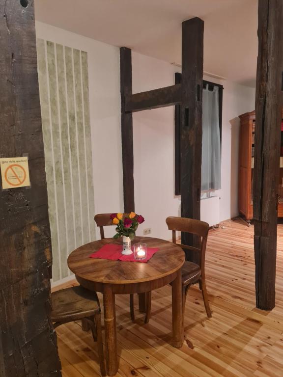 a dining room with a table and chairs and a cross at Gemütliche Wohnung in historischem Kulturdenkmal, 62qm in Hardegsen