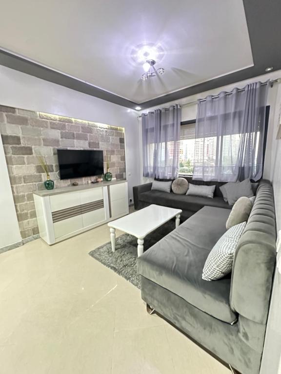 un salon avec un canapé et une télévision dans l'établissement Coastal vibes tanger, à Tanger