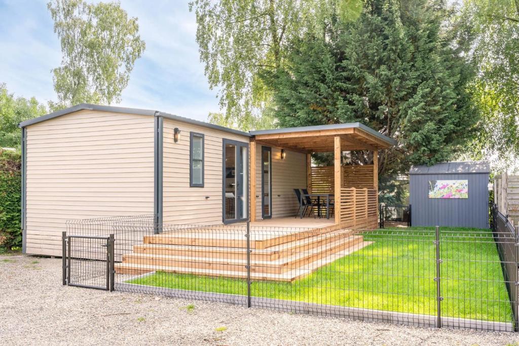 a tiny house with a porch and stairs at Camping Papillon Kinrooi - 82 in Kinrooi