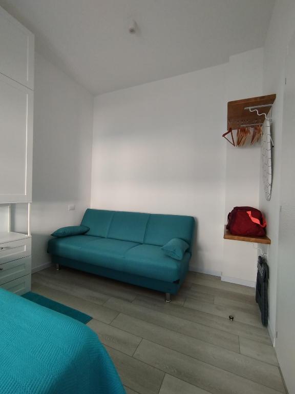 a blue couch in a room with a bed at Seaview Allegra in Montesilvano