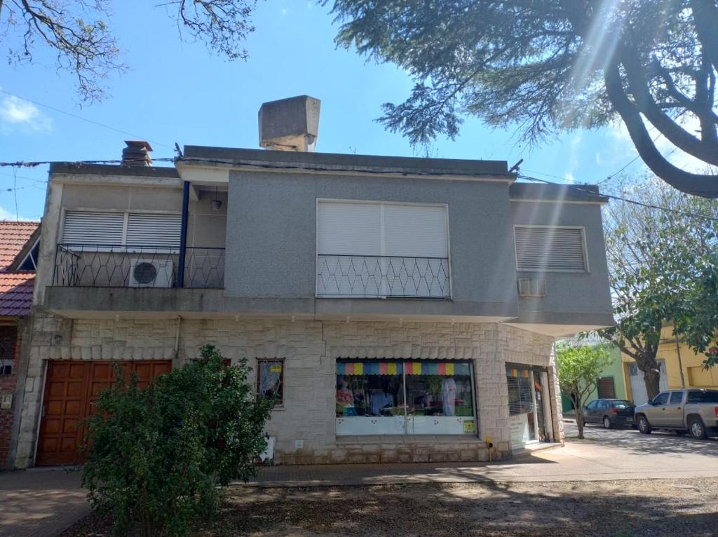 an old house with a balcony on a street at La Casa de Oli in Chascomús
