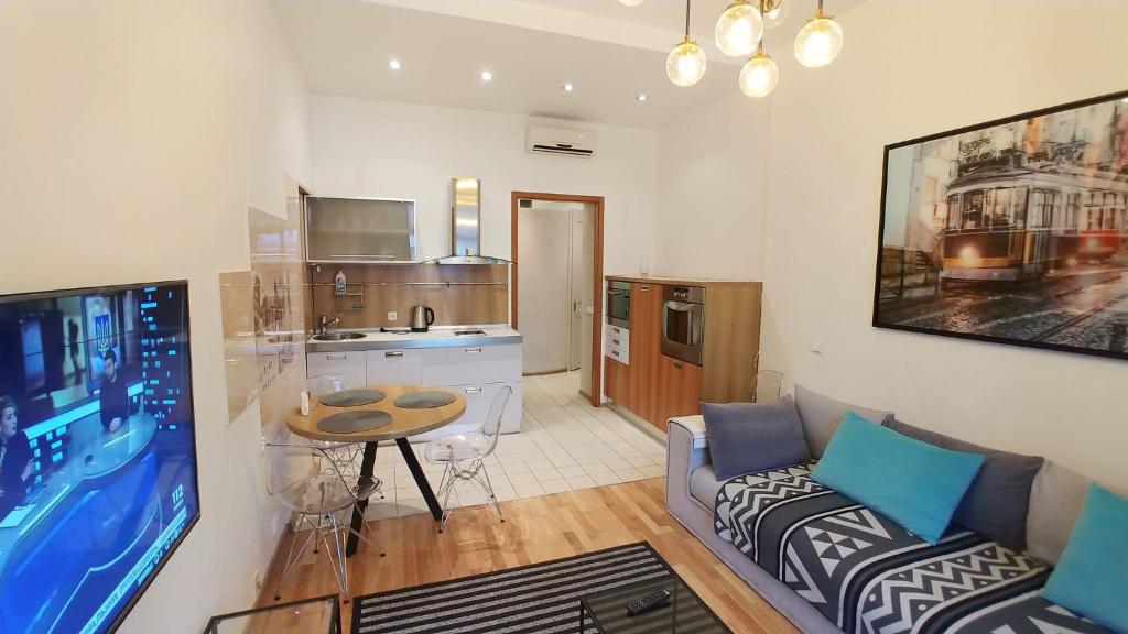 基辅Apartment with terrace on Khreschatyk, Bessarabska Square的客厅里有一张沙发和一个厨房