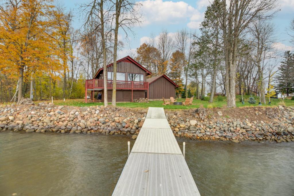 a wooden dock leading to a house on the water at Mille Lacs Lake Retreat! Cabin with Private Dock in Bayview