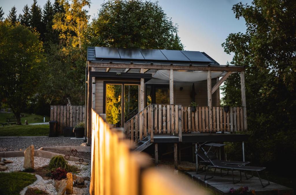 a tiny house with a solar roof on a deck at Nature Living Koralpe in Sankt Stefan im Lavanttal