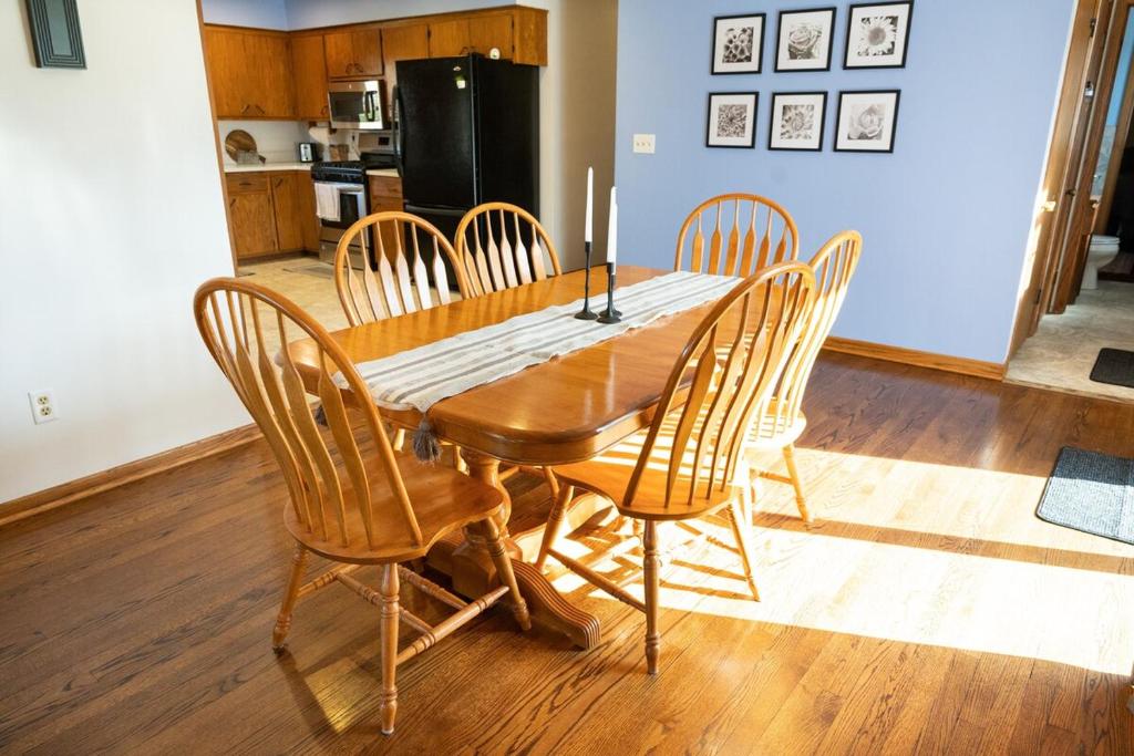 a wooden dining room table with chairs and a kitchen at Convenient Countryside Oasis in Caledonia