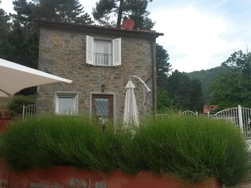 een stenen huis met een paraplu ervoor bij il Fienile di Penelope in Marliana
