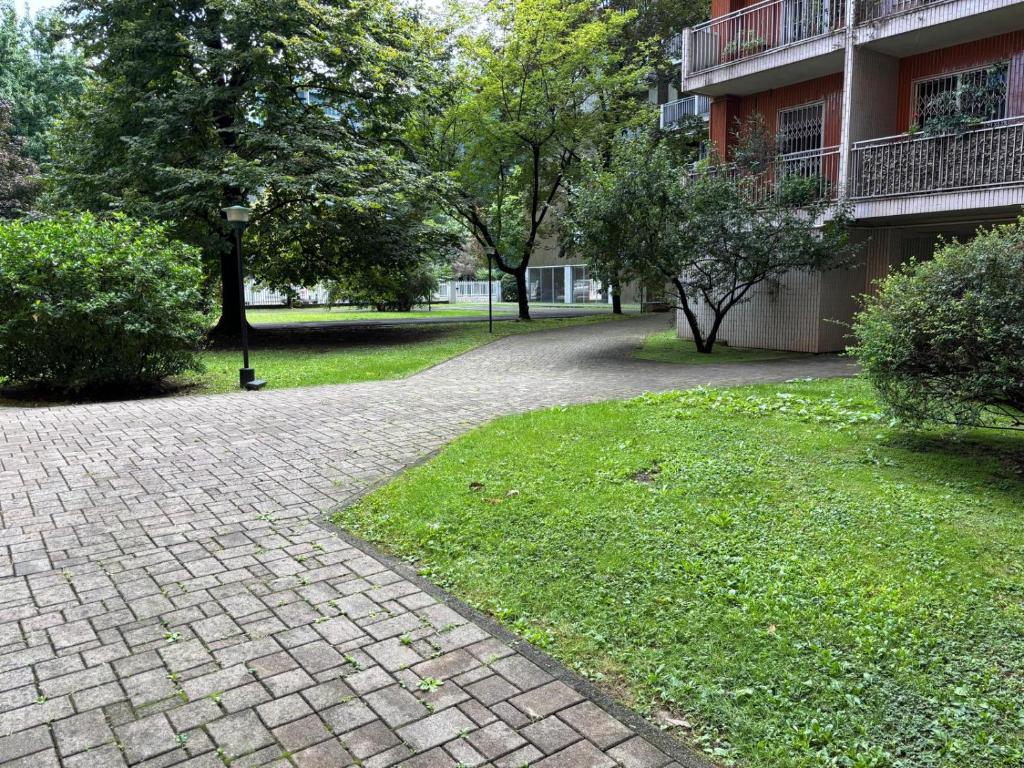 a brick walkway in a park next to a building at Novate Fiera in Novate Milanese