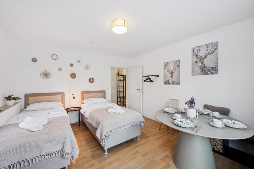 a white room with two beds and a table at KRelax - Bad Wildbad - Moderne Wohnung für 6 Pers in Bad Wildbad