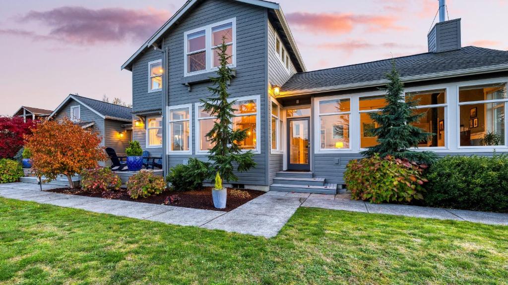 a gray house with a lawn in front of it at 3-Home Coastal Retreat w Sauna Firepit Greenhouse Seabright Haven by AvantStay in Coupeville