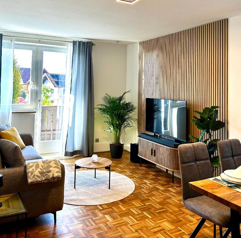 a living room with a couch and a tv at Wallersee Retreat in Neumarkt am Wallersee
