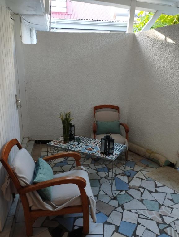 a patio with chairs and a table in a room at Petite Kaz KRÉOL in Basse-Terre